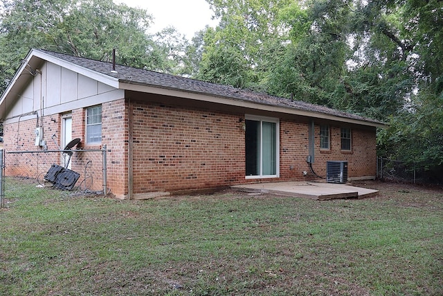 back of house featuring central AC, a patio area, and a lawn