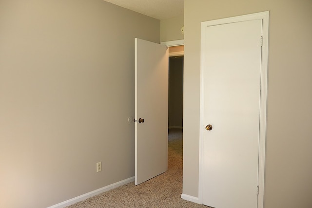 unfurnished bedroom featuring a textured ceiling and light colored carpet