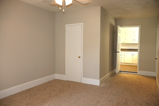 spare room with ceiling fan and carpet