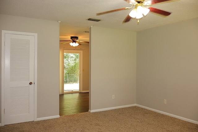 carpeted spare room with a textured ceiling and ceiling fan