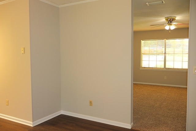 unfurnished room featuring ceiling fan, dark hardwood / wood-style flooring, and crown molding