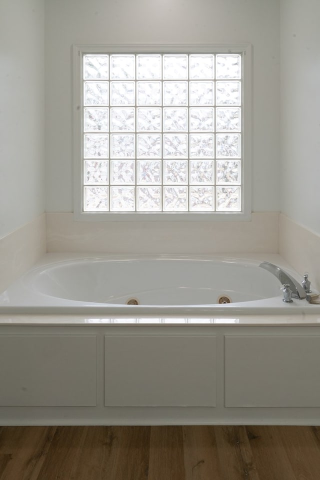 bathroom featuring plenty of natural light and a bath