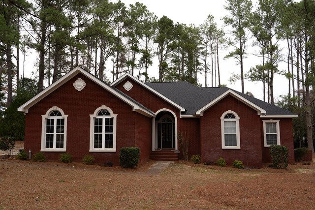 single story home featuring a front lawn