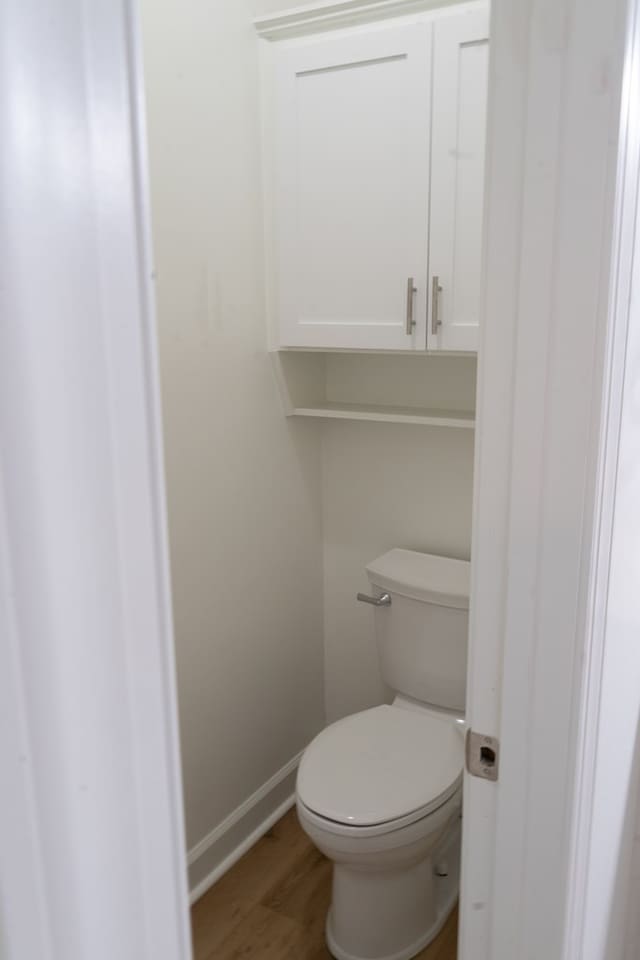 bathroom featuring hardwood / wood-style flooring and toilet