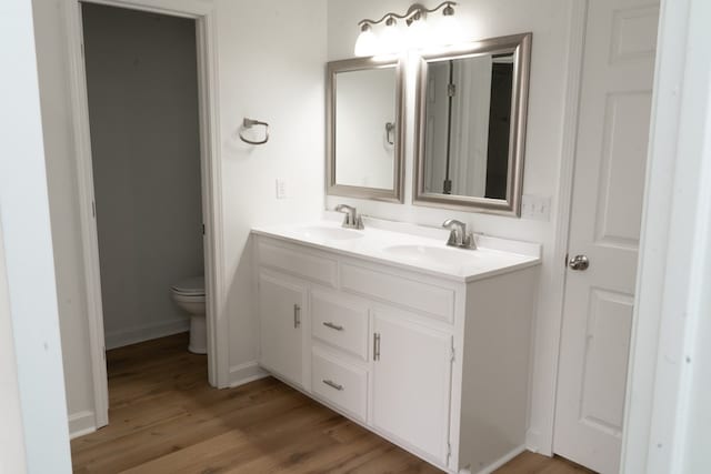 bathroom featuring vanity, hardwood / wood-style flooring, and toilet