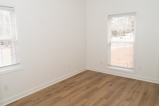 empty room with wood-type flooring and a wealth of natural light