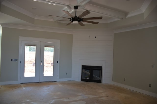 unfurnished living room featuring ceiling fan, a large fireplace, french doors, crown molding, and a tray ceiling