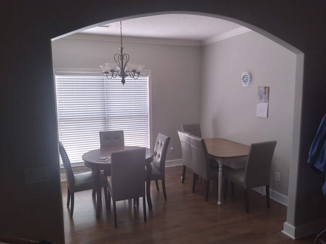 38 Vansant Pl, Dothan, AL 36301 - dining space with arched walkways, a chandelier, crown molding, wood finished floors, and baseboards