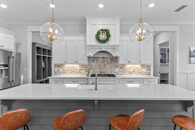 kitchen with white cabinets, light stone counters, and a large island