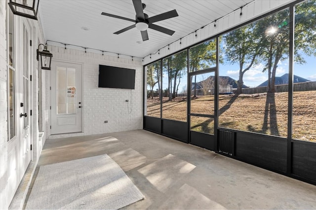 unfurnished sunroom featuring ceiling fan