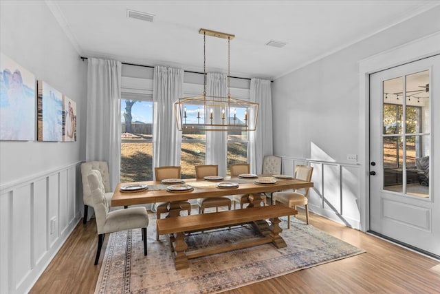 dining room featuring light hardwood / wood-style floors, an inviting chandelier, and crown molding