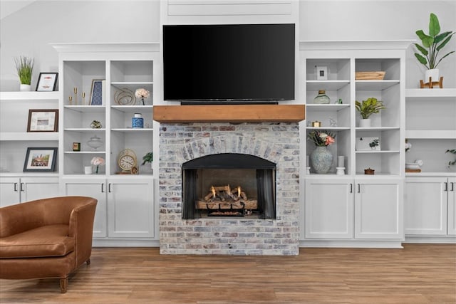 living room with light wood-type flooring and a brick fireplace