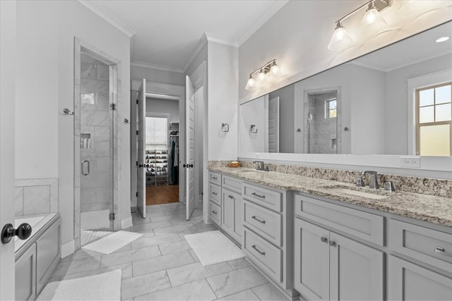 bathroom with vanity, a shower with door, and crown molding