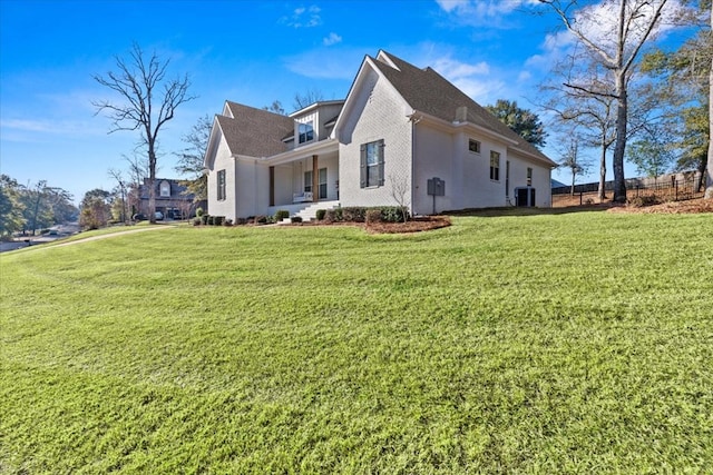 view of side of property with central AC unit and a yard