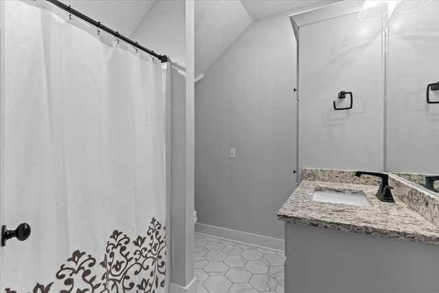 bathroom with tile patterned flooring, vanity, lofted ceiling, and walk in shower