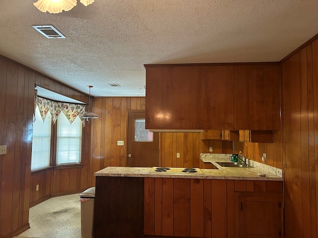 kitchen with white cooktop, wood walls, and kitchen peninsula