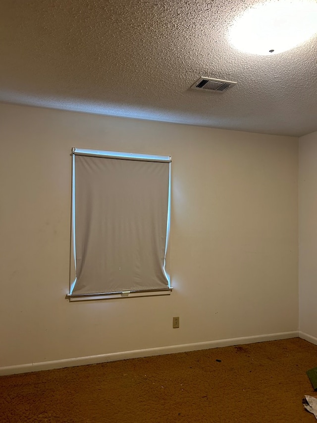 carpeted spare room featuring a textured ceiling