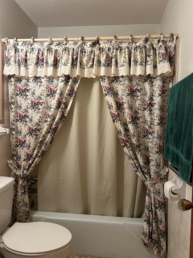 bathroom featuring a textured ceiling and toilet