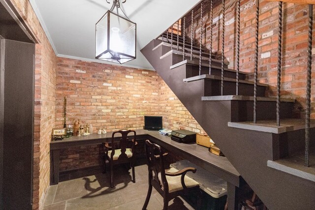 wine area featuring crown molding and brick wall