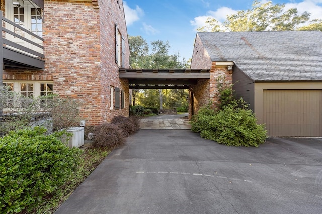 view of side of property featuring central AC unit and a carport