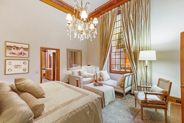 bedroom featuring hardwood / wood-style flooring, an inviting chandelier, multiple windows, and ensuite bathroom