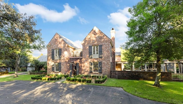 tudor home featuring a front lawn