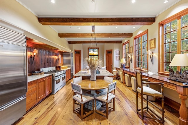 kitchen with beam ceiling, high quality appliances, light hardwood / wood-style floors, and decorative light fixtures