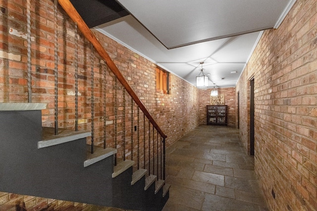 corridor featuring brick wall and ornamental molding