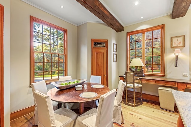 dining area with beam ceiling, light hardwood / wood-style floors, and ornamental molding