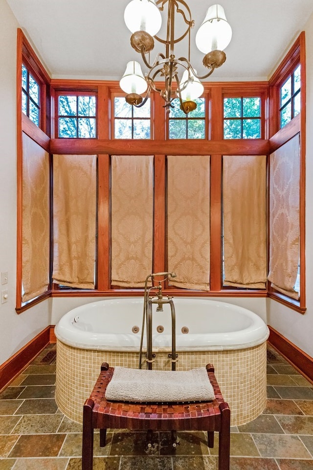 bathroom with a relaxing tiled tub and a chandelier