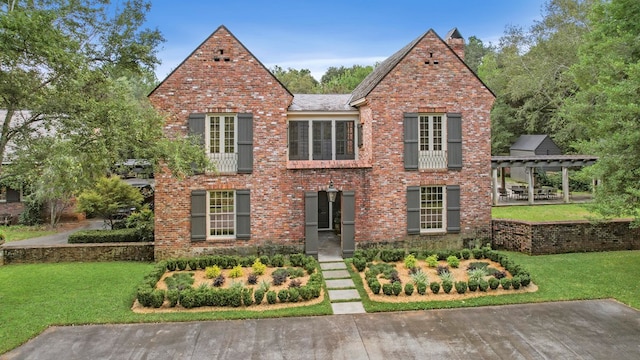 view of front of property featuring a pergola and a front lawn