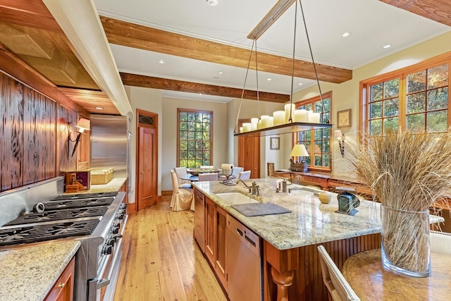 kitchen with a wealth of natural light, light stone counters, and high end appliances