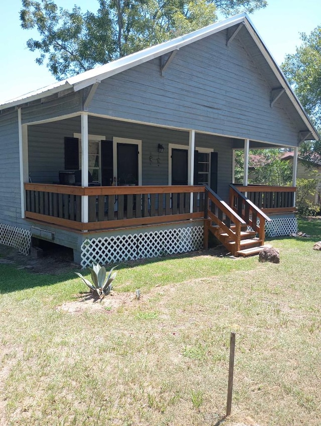 back of house featuring a yard and covered porch