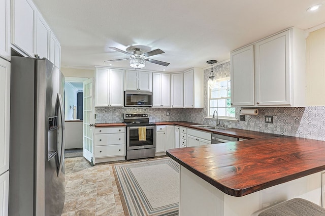 1810 Northside Dr, Dothan, AL 36303 - kitchen with appliances with stainless steel finishes, a sink, a peninsula, wooden counters, and a ceiling fan