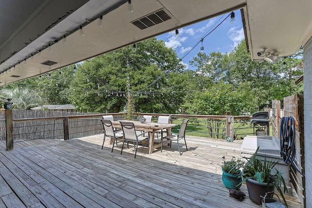 1810 Northside Dr, Dothan, AL 36303 - wooden deck featuring outdoor dining space, a fenced backyard, and view of scattered trees