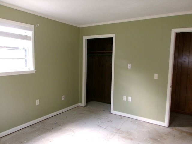 unfurnished bedroom featuring a closet, crown molding, and baseboards