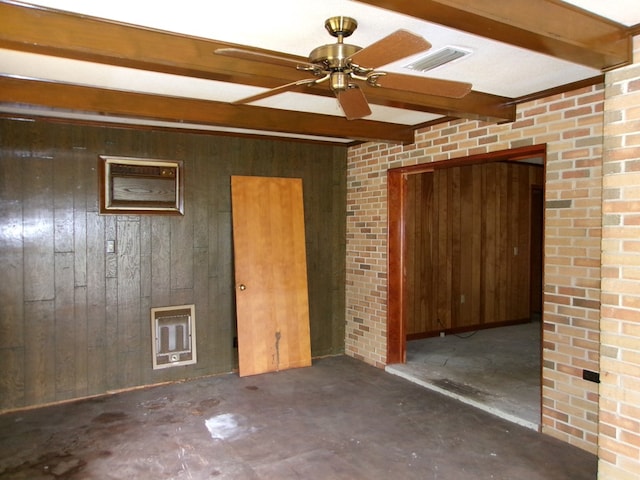empty room featuring visible vents, a ceiling fan, beam ceiling, wooden walls, and unfinished concrete floors
