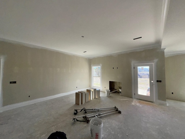 unfurnished living room with crown molding and a wealth of natural light