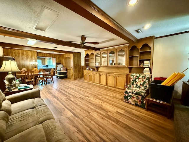 152 W Cox St, Slocomb, AL 36375 - living room with wood walls, light wood-type flooring, ceiling fan, a textured ceiling, and crown molding