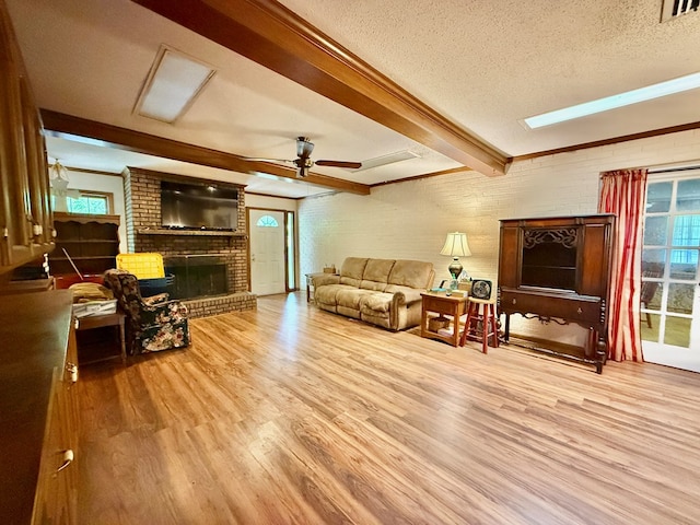 152 W Cox St, Slocomb, AL 36375 - living area with wood finished floors, beam ceiling, a brick fireplace, a ceiling fan, and a textured ceiling