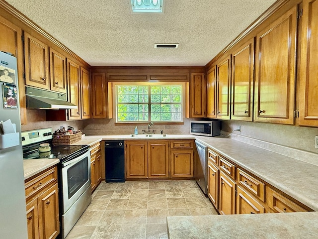 152 W Cox St, Slocomb, AL 36375 - kitchen featuring stainless steel appliances, under cabinet range hood, brown cabinetry, light countertops, and a sink