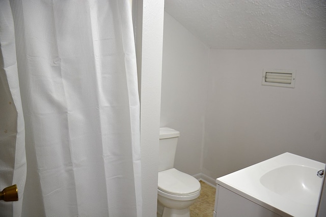 full bath with tile patterned floors, vanity, a textured ceiling, and toilet