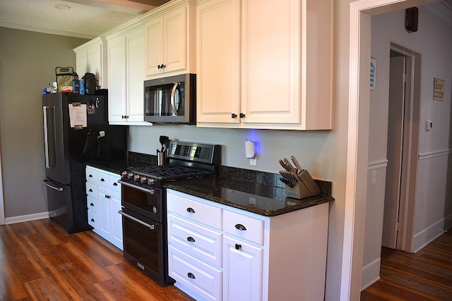 kitchen with freestanding refrigerator, stainless steel microwave, double oven range, and dark wood-style flooring