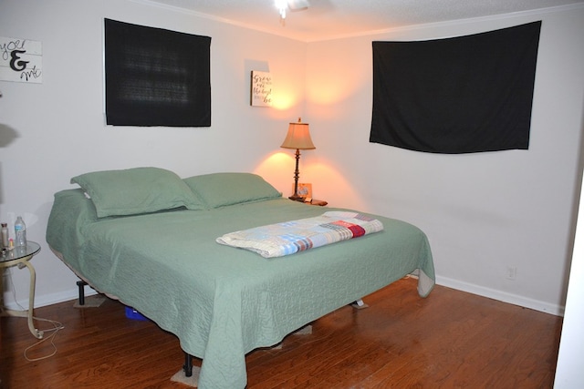 bedroom featuring baseboards and wood finished floors