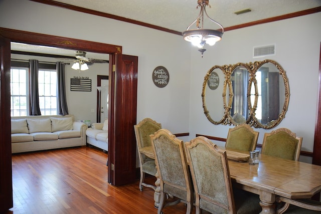 dining room featuring crown molding, visible vents, and wood finished floors
