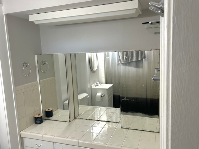 full bath featuring toilet, a stall shower, and vanity