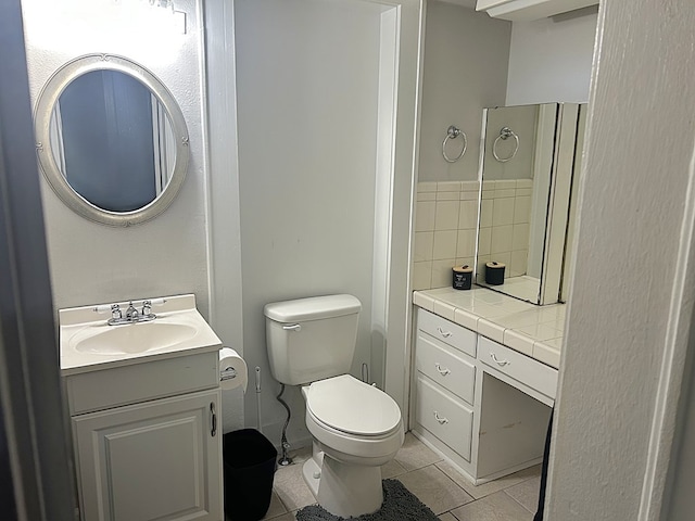 bathroom with toilet, tile patterned floors, and vanity