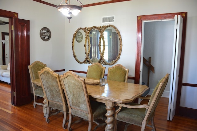 dining space with ornamental molding, visible vents, and wood finished floors