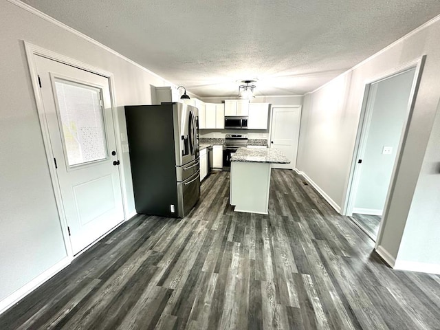 kitchen featuring white cabinetry, a center island, stainless steel appliances, light stone counters, and dark hardwood / wood-style flooring