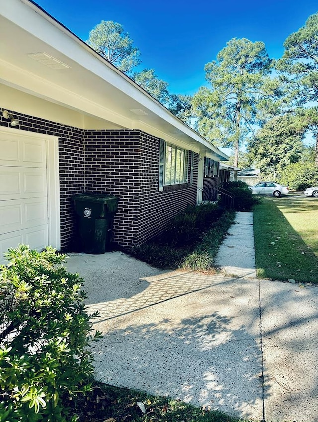 view of home's exterior with an attached garage and brick siding